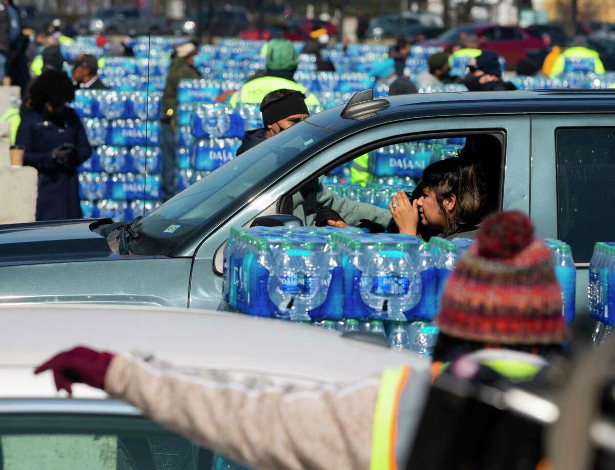 Houston residents wait in line to get free bottled water at a mass distribution Friday, Feb. 19, 2021, at Delmar Stadium in Houston. The city is still under boil water order and some places are still having low water pressure.