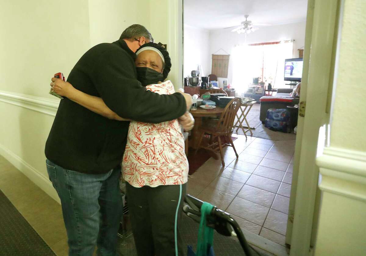 Parkdoll Jackson Burks, gets a hug from Jerry Garcia, Harris County Constable Precint 2, who was delivering meals from the Houston Food Bank at the Big Bass Resort, in Houston, Thursday, February 18, 2021. The Big Bass Resort, which is home to mostly seniors was out of power for three days after a winter storm left people without power and water along with freezing temperatures. She was cooking her meals with sterno cans on top of a tin roasting pan and delivering the meals with a lantern in the darkened hallways.