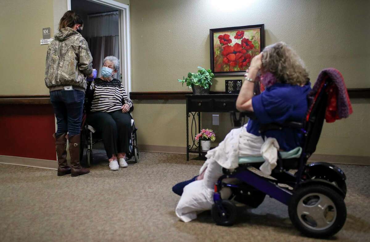 Darah Galloway, left, gives Nina Ponfick a cup of hot chocolate Thursday, Feb. 18, 2021, at Bayou Pines Care Center in La Marque.