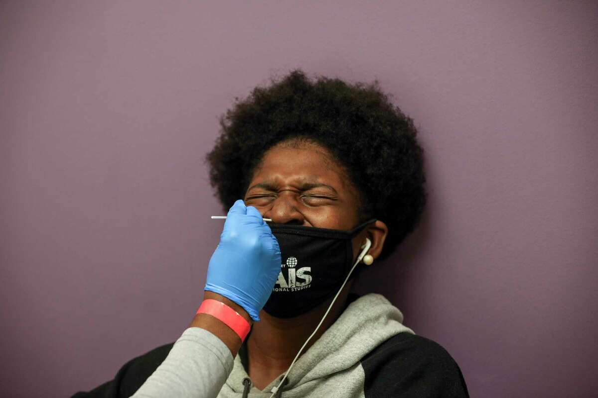 Animi Williams, 14, reacts as she has a nasal swab performed as part of a Moderna vaccine trial for teenagers Saturday, Feb. 13, 2021, at CyFair Clinical Research Center in Houston.