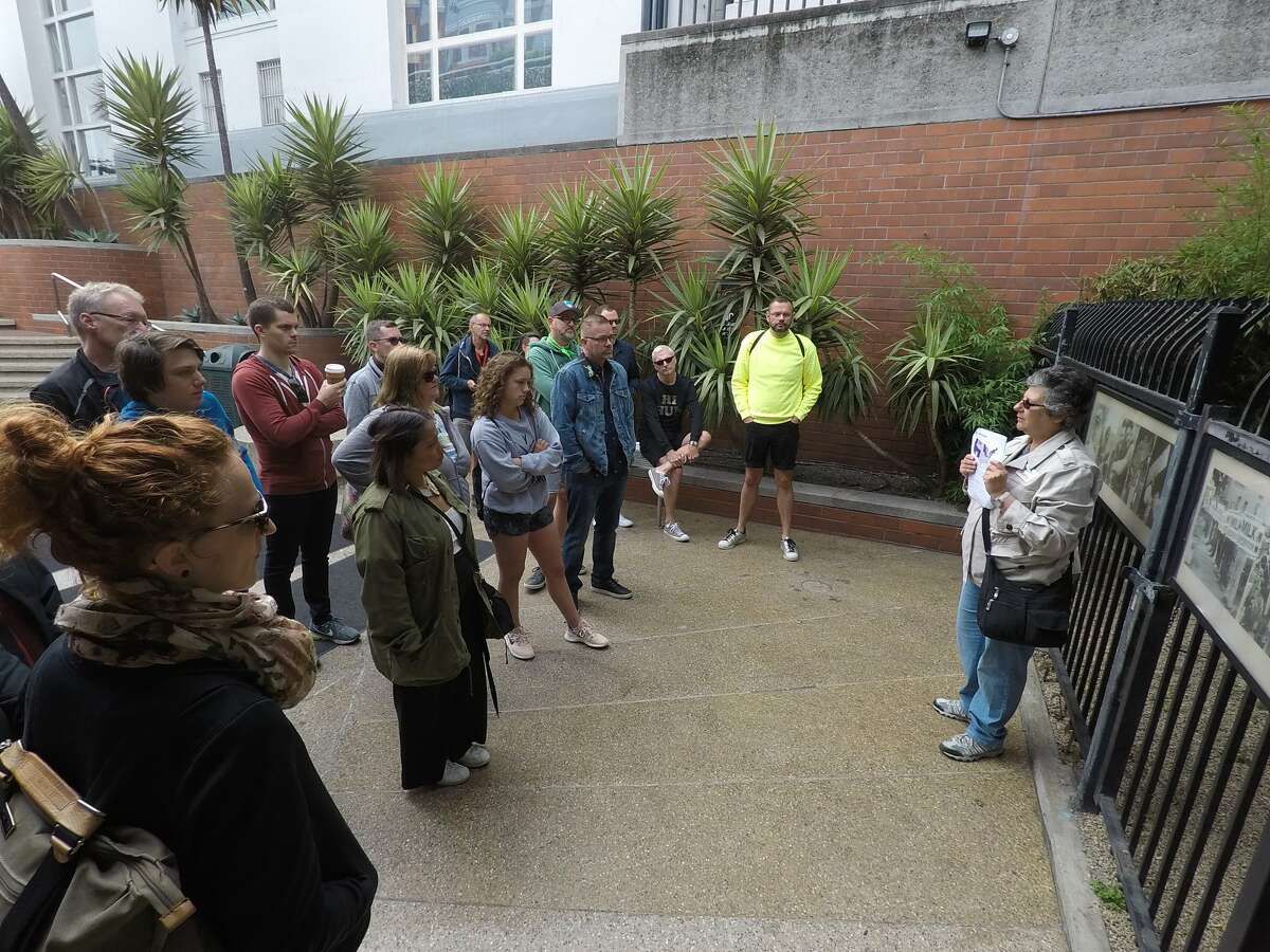 Kathy Amendola, owner of Cruisin’ the Castro Walking Tours, leads a group to the Harvey Milk Plaza at Muni’s Castro Station in 2018.