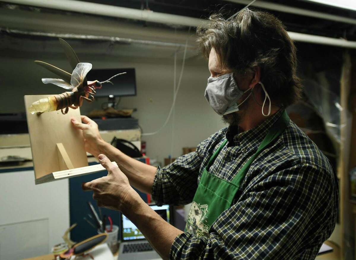 Exhibition Preparator Sean Murtha holds a firefly model that he created for the new Natural Cycles Shape Our Land exhibition in the permanent science galleries under construction at The Bruce Museum in Greenwich, Conn. on Wednesday, February 17, 2021.