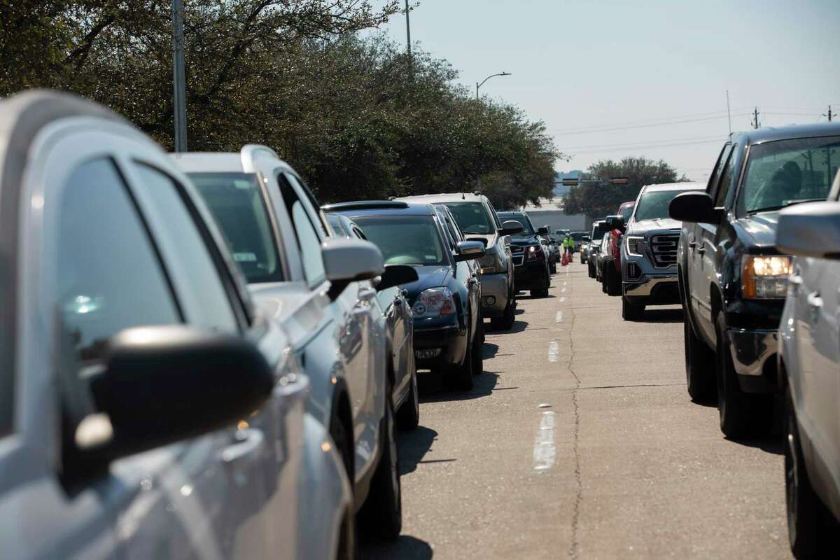 Houston residents wait in line to get free bottled water at a mass distribution Friday, Feb. 19, 2021, at Delmar Stadium in Houston. The city is still under boil water order and some places are still having low water pressure.