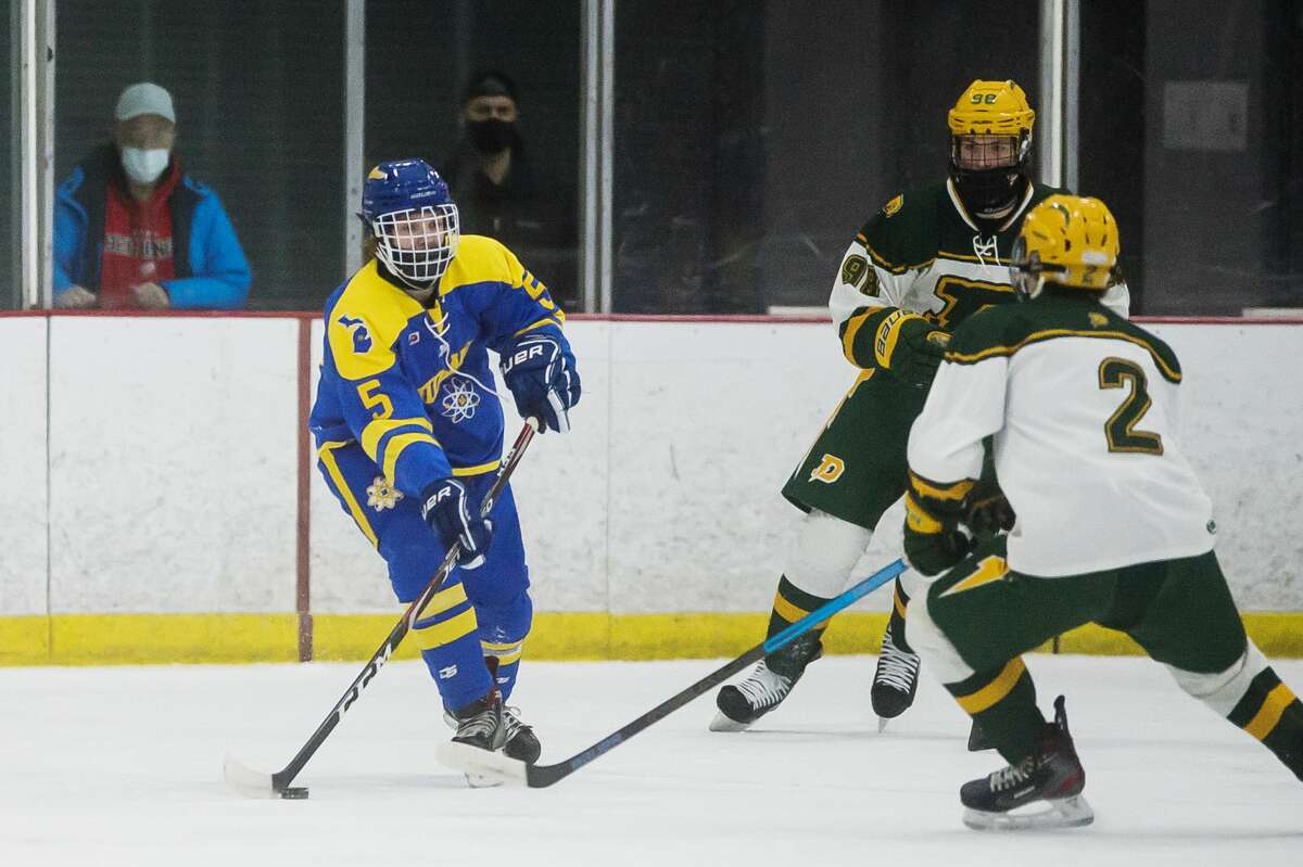 Midland High's Ben Haney moves the puck down the ice during a game against Dow High on Feb. 19, 2021.