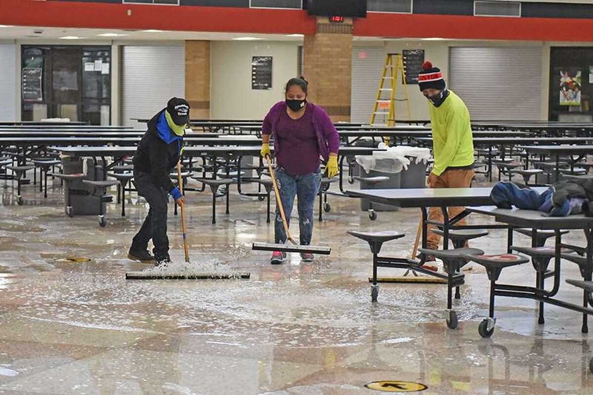 Water is cleaned up from the floor of Langham Creek High School by restoration crews after the winter storm resulted in pipe damage at the campus.