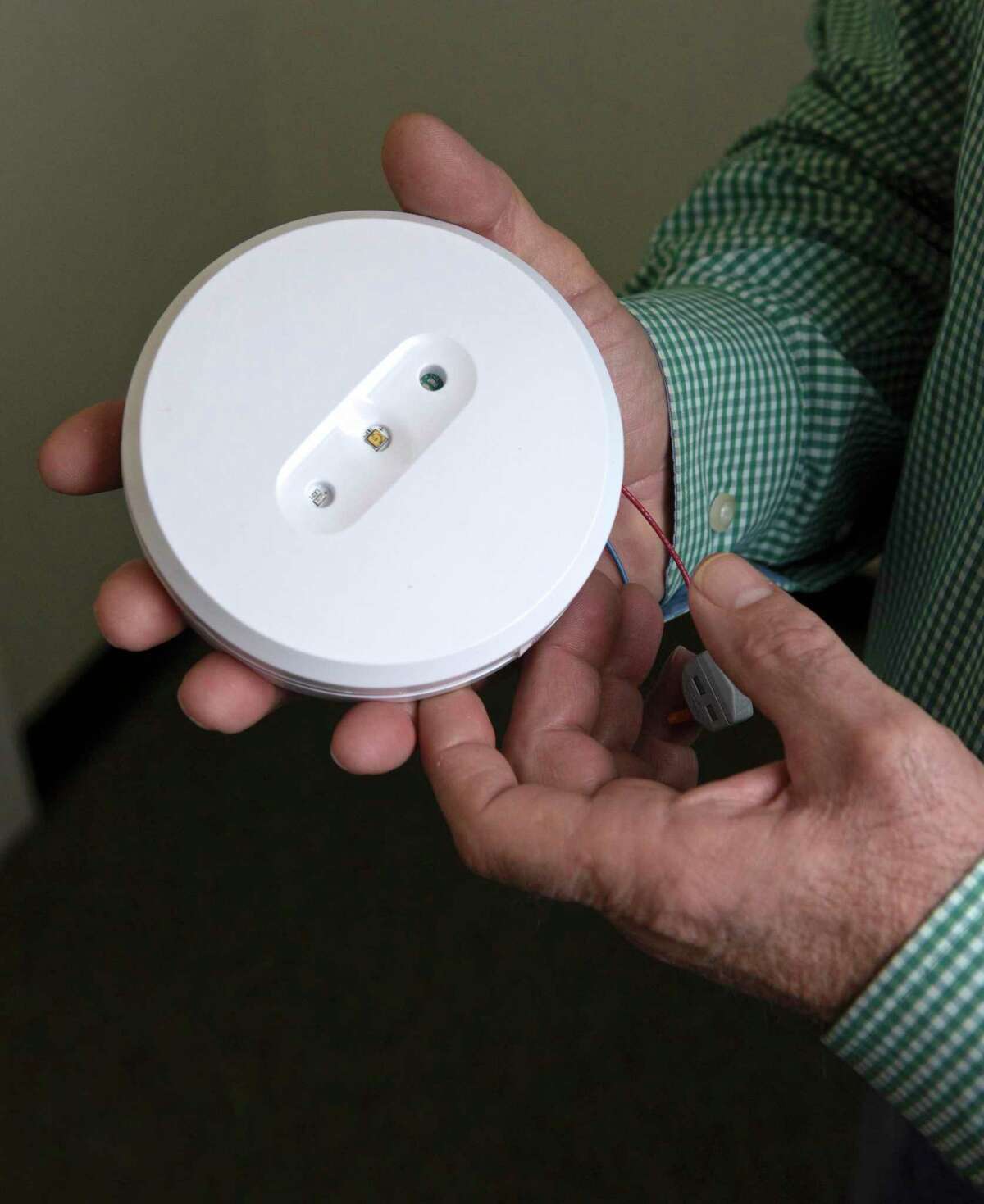 Southbury First Selectman Jeff Manville holds a ultraviolet light-emitting device like the ones installed in Southbury Town Hall at the entranceways to the building and restrooms. The units emit ultraviolet C light to destroy airborne germs, including the coronavirus. Friday, February 19, 2021, in Southbury, Conn.