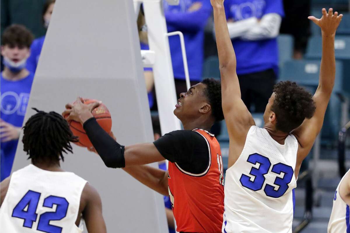 Bush's Tyler Smith, middle, puts up a shot between Katy Taylor's Troy Harris (42) and Elijah Melchiorre (33) during a 6A district boys high school basketball playoff game Saturday, Feb. 20, 2021 at the Merrell Center in Katy, TX.