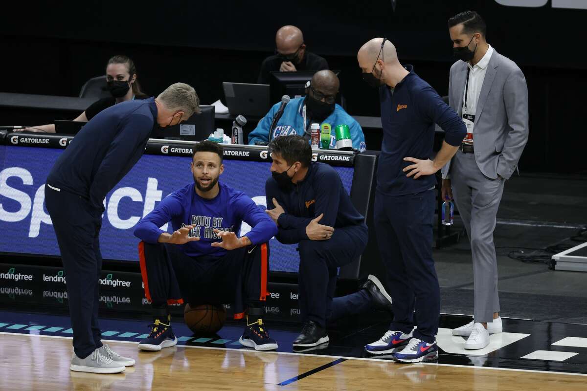 Golden State Warriors Stephen Curry speaks with head coach Steve Kerr and staff ahead of their game against the Charlotte Hornets on February 20, 2021.