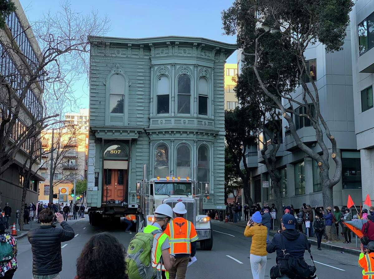 A crowd follows a Victorian home as it parades the wrong way down the street to its new home at a top speed of 1 mph. It was the first time such a home was relocated in S.F. in 50 years.