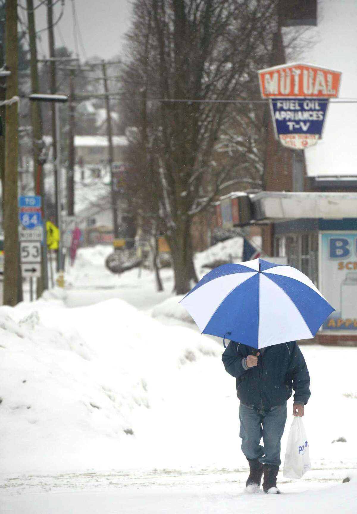 John Dlugozima, of Danbury, walks home from the store during Thursdays snow storm. February 18, 2021, in Danbury, Conn.