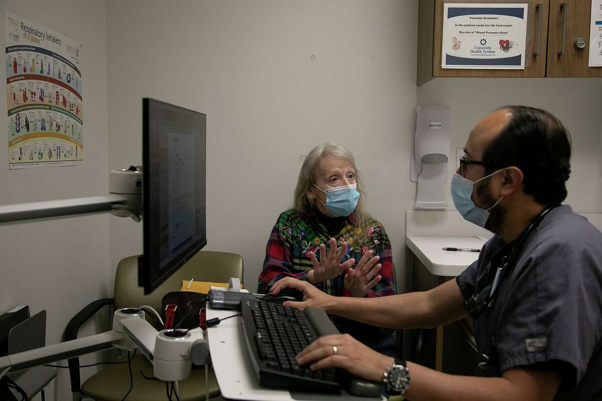 Dr. Diego Maselli, a UT Health San Antonio pulmonologist, visits with asthma patient Diane Hearn at University Health’s Robert B. Green Campus.