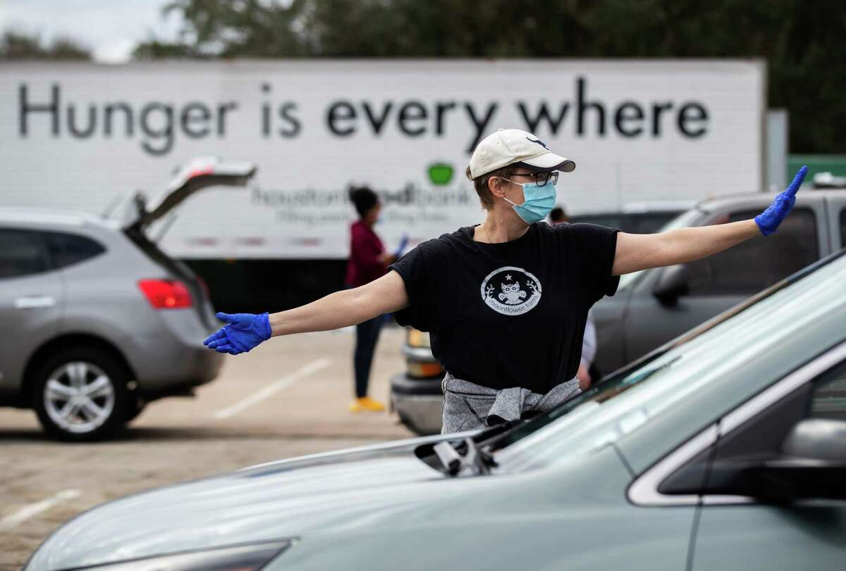 Houston Food Bank volunteer Cecilie Tindlund, directs traffic during a food distribution event at NRG Park, Sunday, Feb. 21, 2021, in Houston.