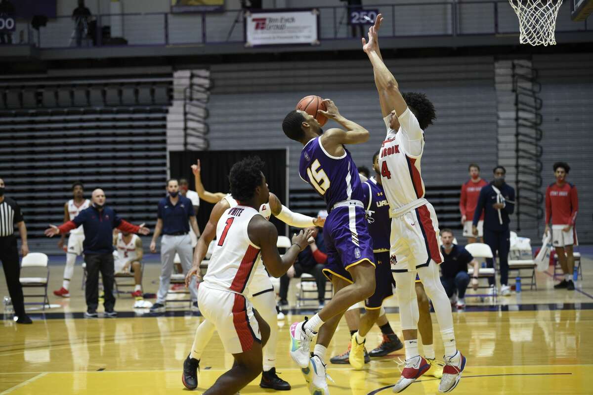 UAlbany guard C.J. Kelly looks to shoot betrween Stony Brook defenders Juwan White (1) and Tykei Greene (4) in an America East basketball game Sunday, Feb. 22, 2021, at SEFCU Arena in Albany. (Kathleen Helman/UAlbany athletics)