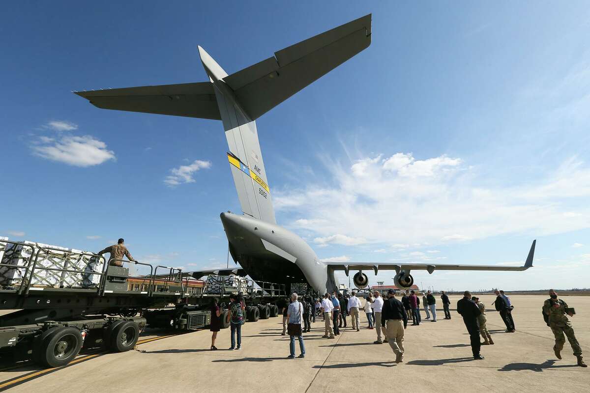 Troops unload bottled water from a C-17 cargo plane Sunday at Port San Antonio.