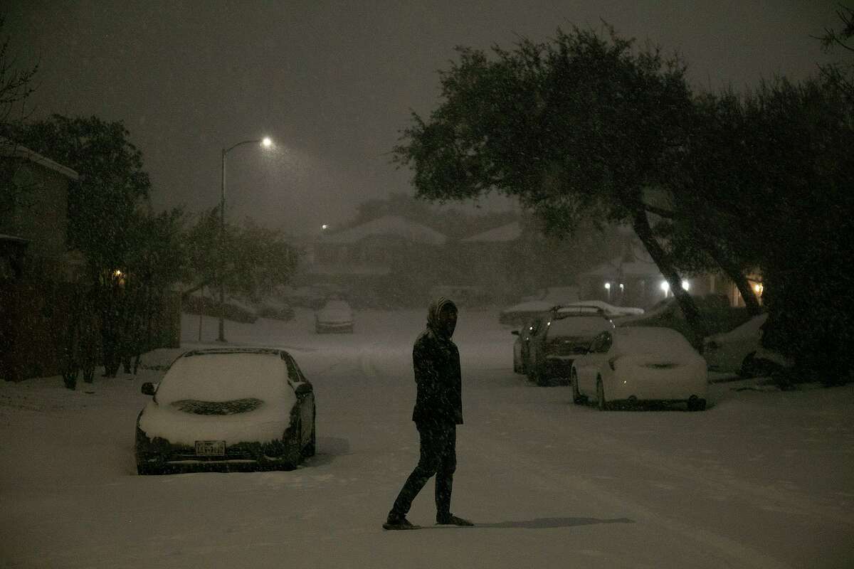 Umair Iqbal watches the snow fall early in the morning on Feb. 15 in San Antonio. The rolling blackouts around the state have triggered lawsuits against the Electric Reliability Council of Texas Inc., which manages the state’s power grid.