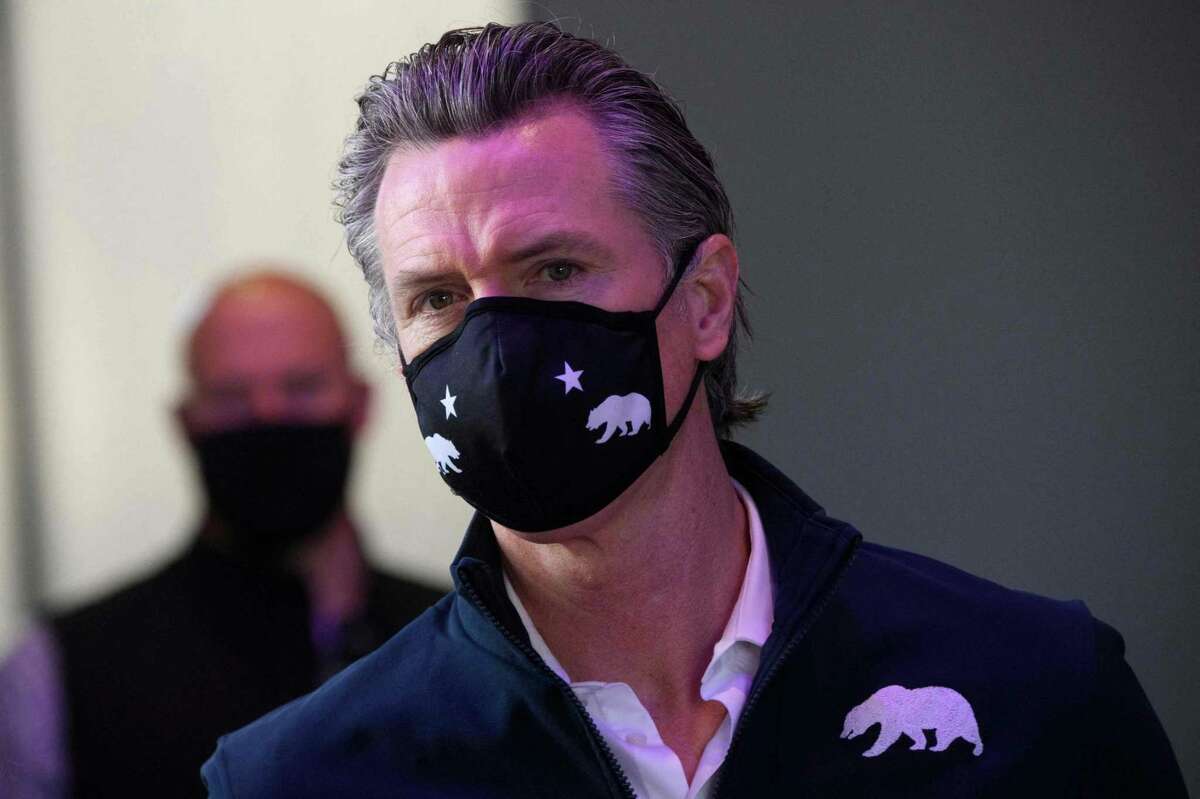 California Gov. Gavin Newsom wears a face mask as he prepares to give a briefing after touring a COVID-19 vaccination site on Feb. 22, 2021, in Long Beach, Calif.