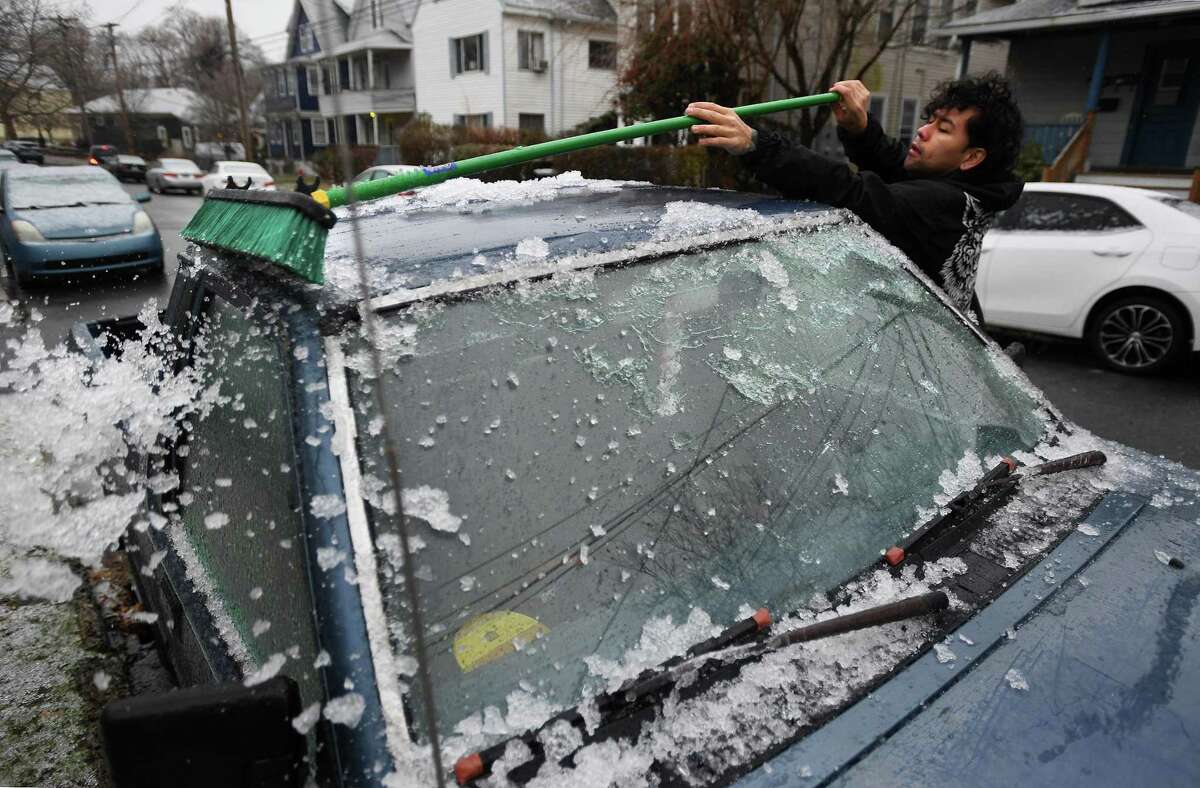 A file photo of a resident clearing ice and snow from his vehicle as he heads to work from his home on Midland Street in the Black Rock section of Bridgeport, Conn., taken on Tuesday, December 17, 2019.