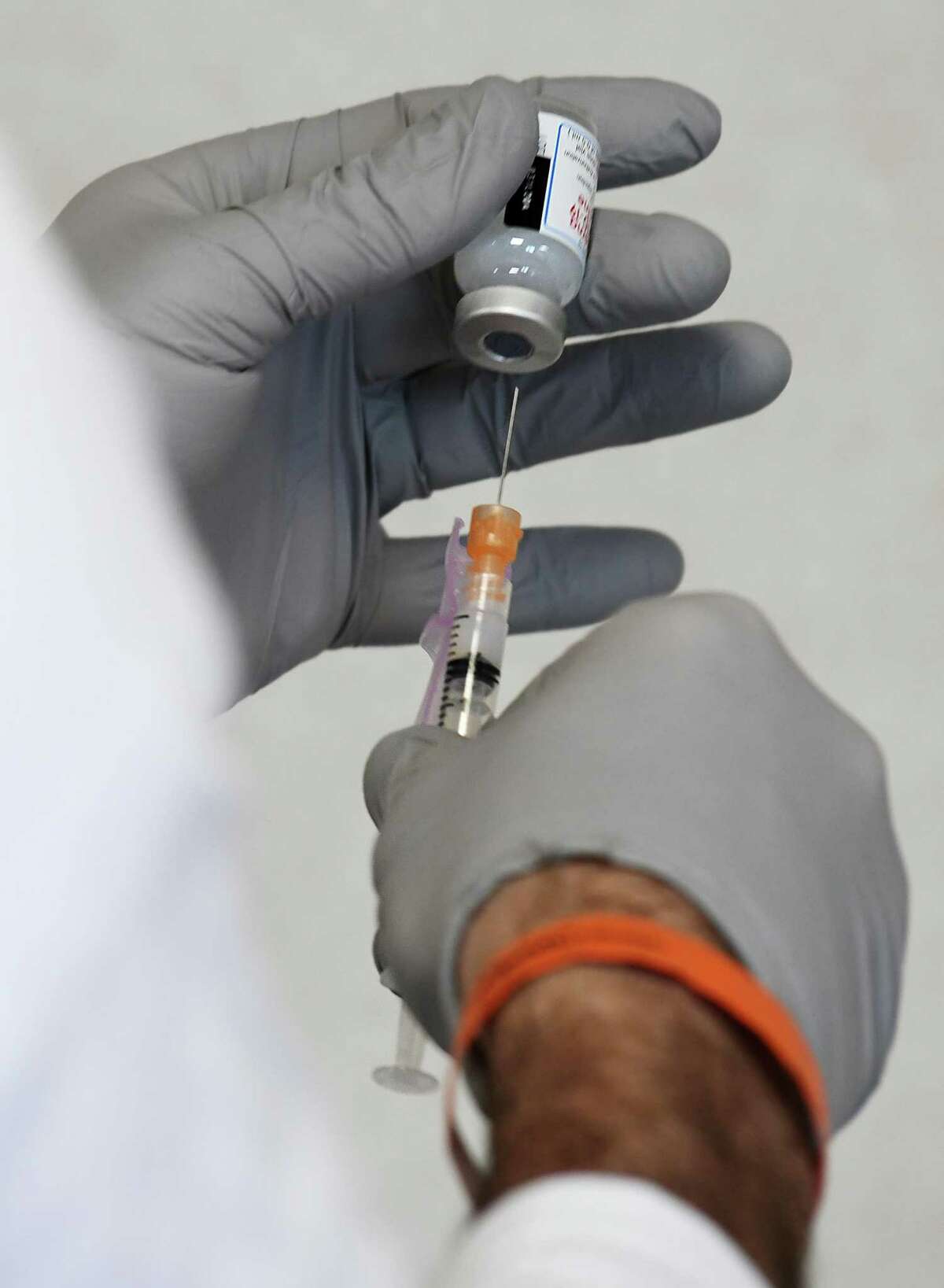 Cameron Wallace, a member of the GEMS vaccination team, preps a vaccine at the Town of Greenwich COVID-19 vaccination clinic at Town Hall in Greenwich, Conn. Thursday, Jan. 28, 2021.