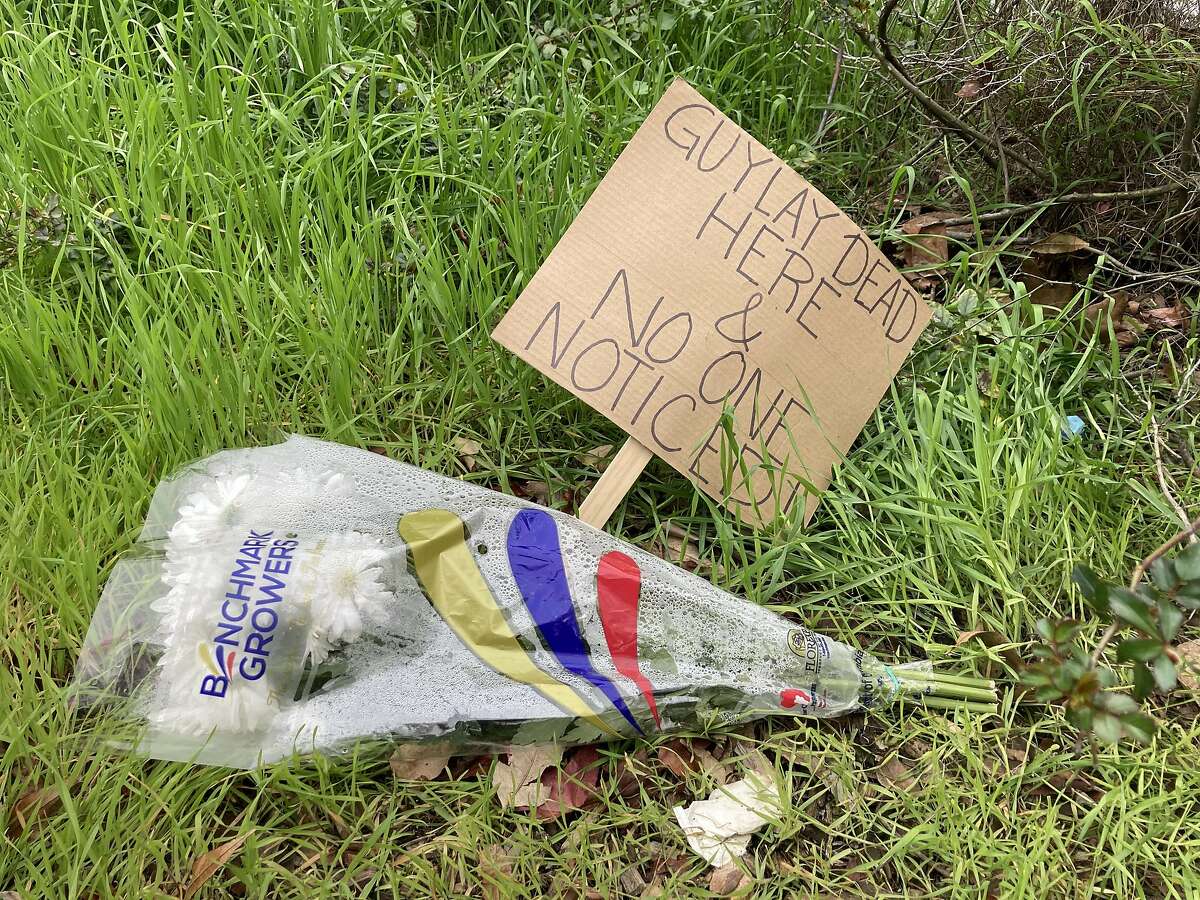 帕亚尔·古普塔在韦伯斯特和布什街中间留下了一束花和一块牌子，那里有一名男子死亡。