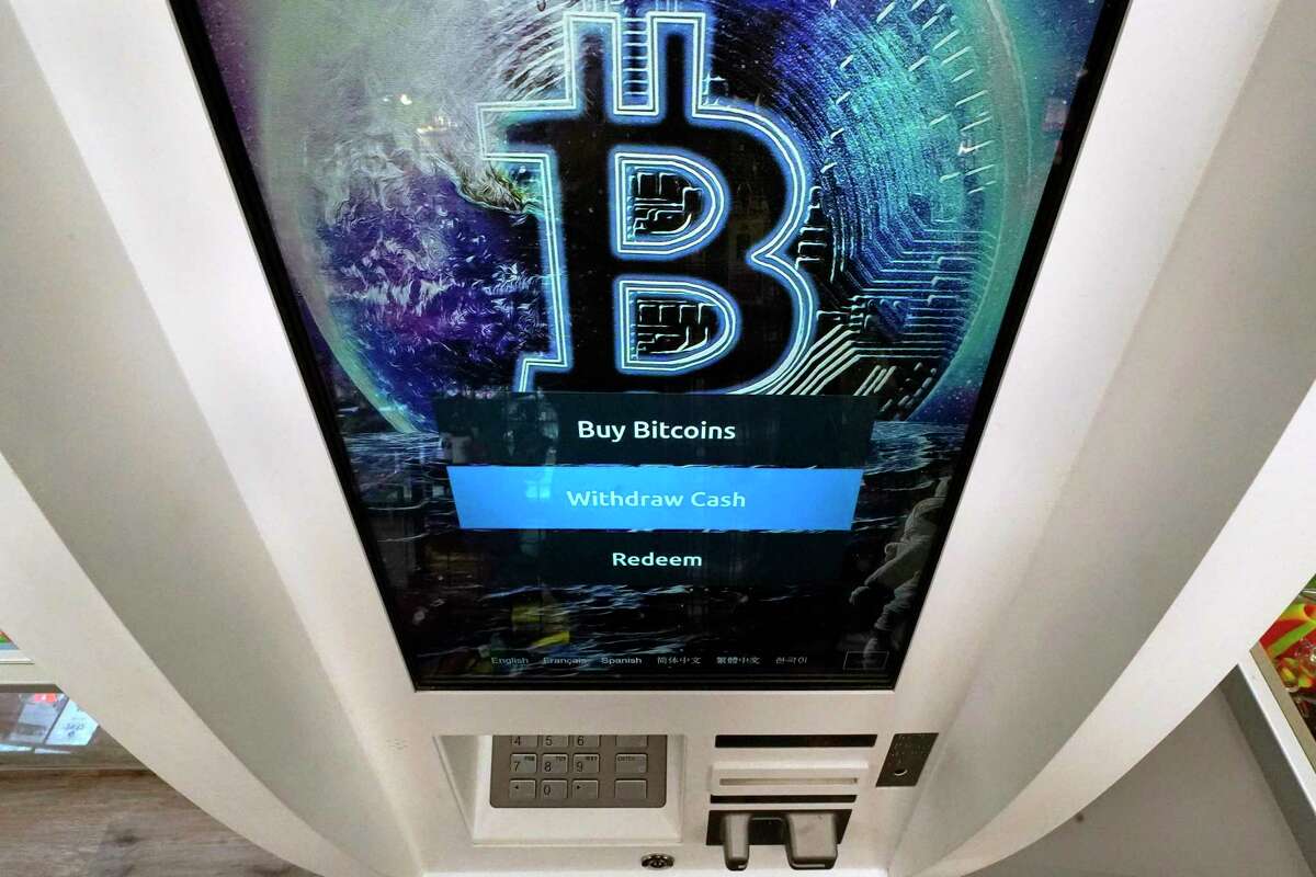 The Bitcoin logo appears on the display screen of a crypto currency ATM at the Smoker's Choice store, Tuesday, Feb. 9, 2021, in Salem, N.H. After a wild week in which Bitcoin soared to new heights, Bitcoin is crossing the $50,000 mark. Bitcoin rallied last week as more companies signaled the volatile digital currency could eventually gain widespread acceptance as a means of payment for goods and services. (AP Photo/Charles Krupa)