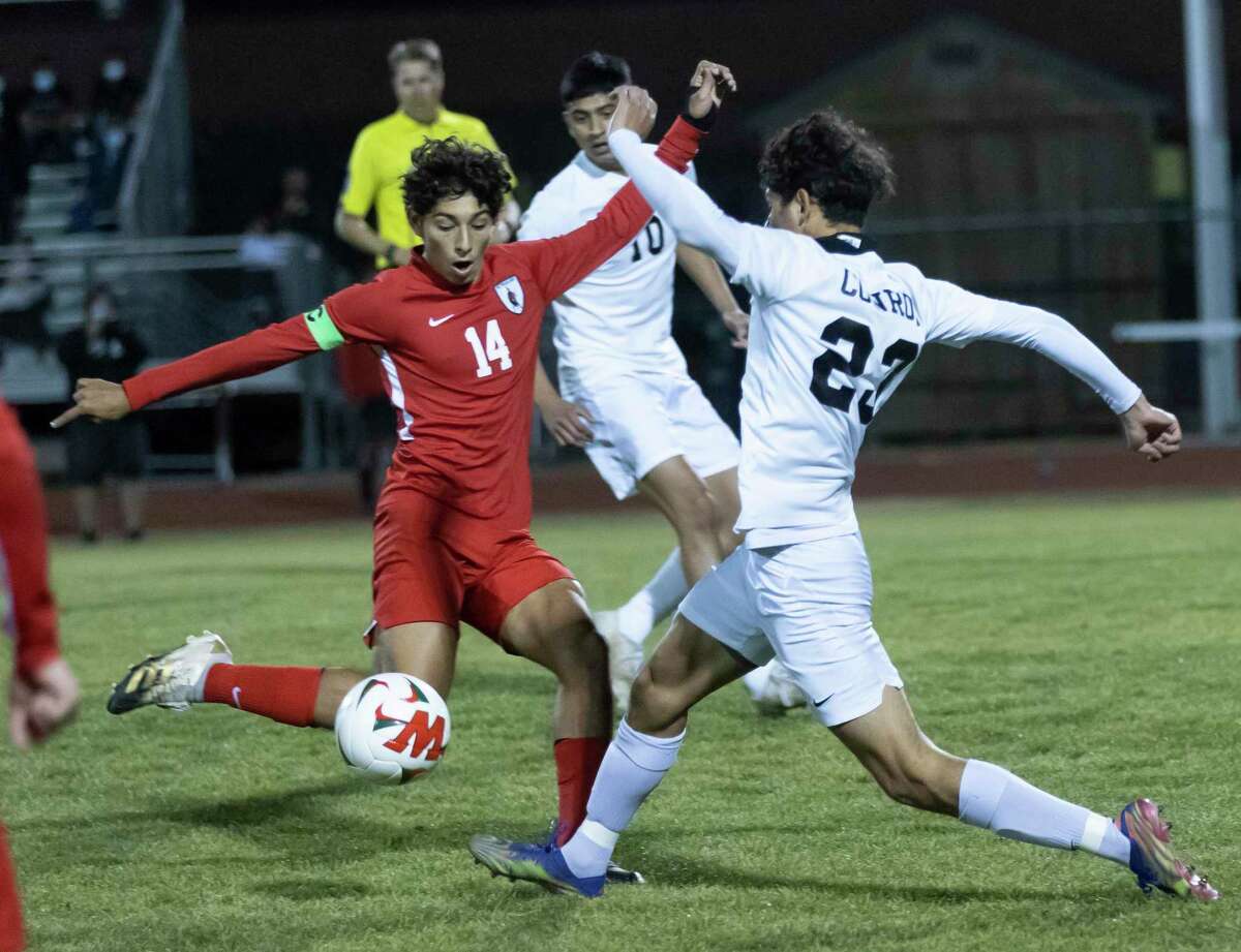 The Woodlands midfielder Tomas Cabrales (14) and Conroe Julian Vega (23) fight for control of the ball during the first half of a District 13-6A boys soccer at The Woodlands High School, Tuesday, Feb. 23, 2021, in The Woodlands.