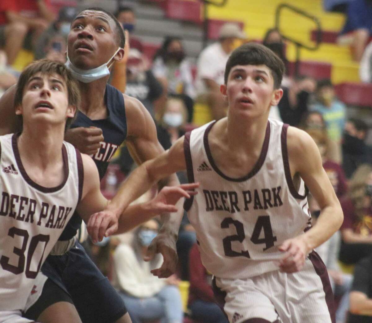 The Deer Park duo of Garrett Topping (left) and Andrew Aguilar  put the squeeze on Atascocita's Tom Hart as the three vie for a possible rebound Tuesday night.