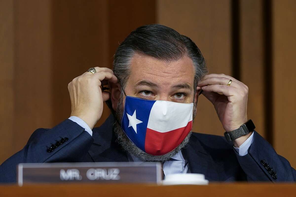 Sen. Ted Cruz, R-Texas, adjusts his face covering on Capitol Hill in Washington. 