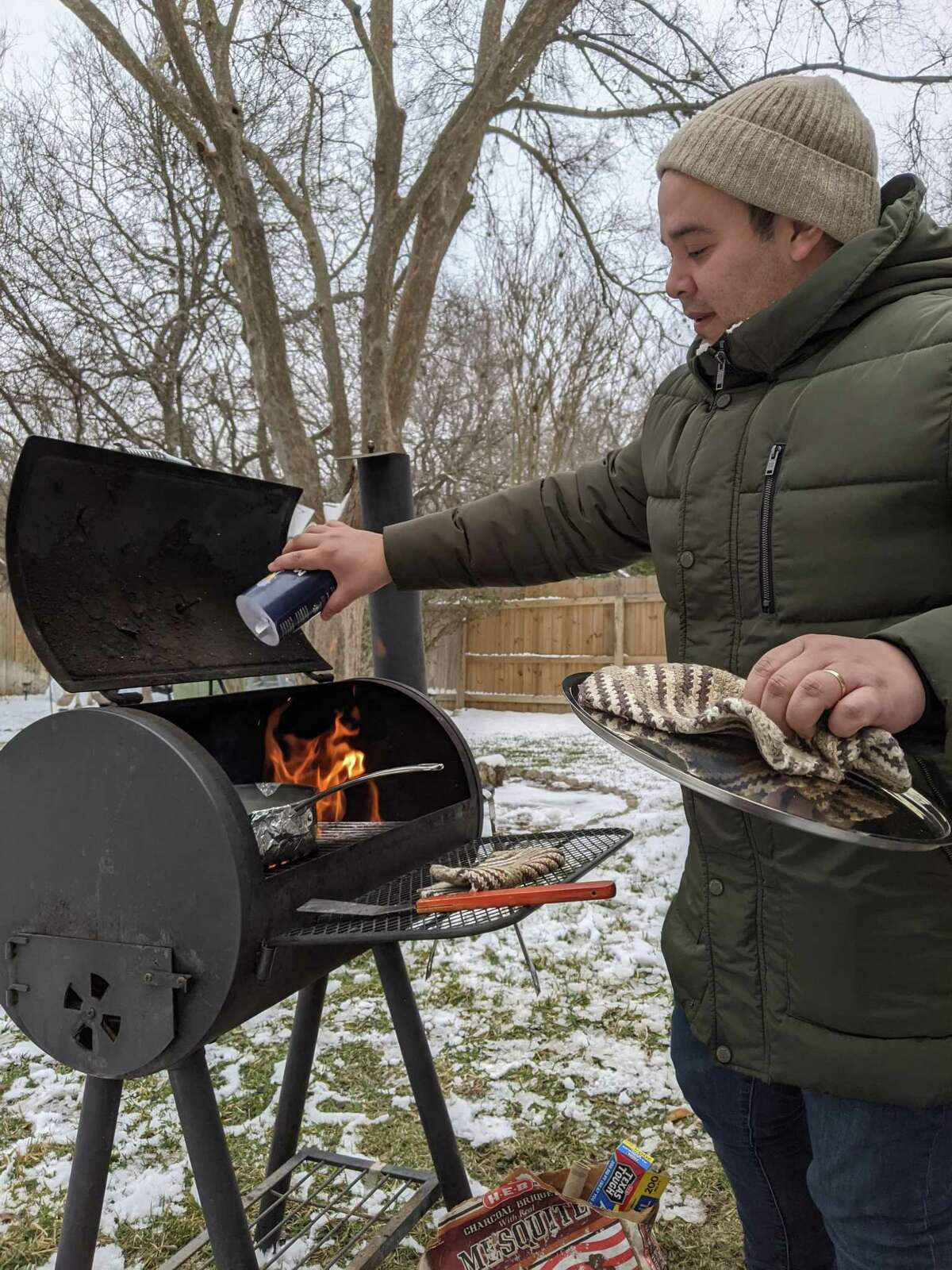 Francisco Chagolla Retzloff cooks on an outdoor grill he used to prepare almost every meal he and his husband Timothy Chagolla Retzloff ate for three days while the power was off in their North West side home. Timothy said he'll never be caught short on firewood and charcoal again.