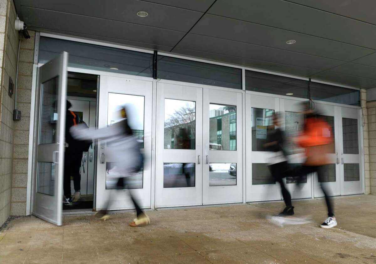 Students enter the Academy of Information Technology & Engineering (AITE) in Stamford, Conn. Tuesday, Feb. 23, 2021.