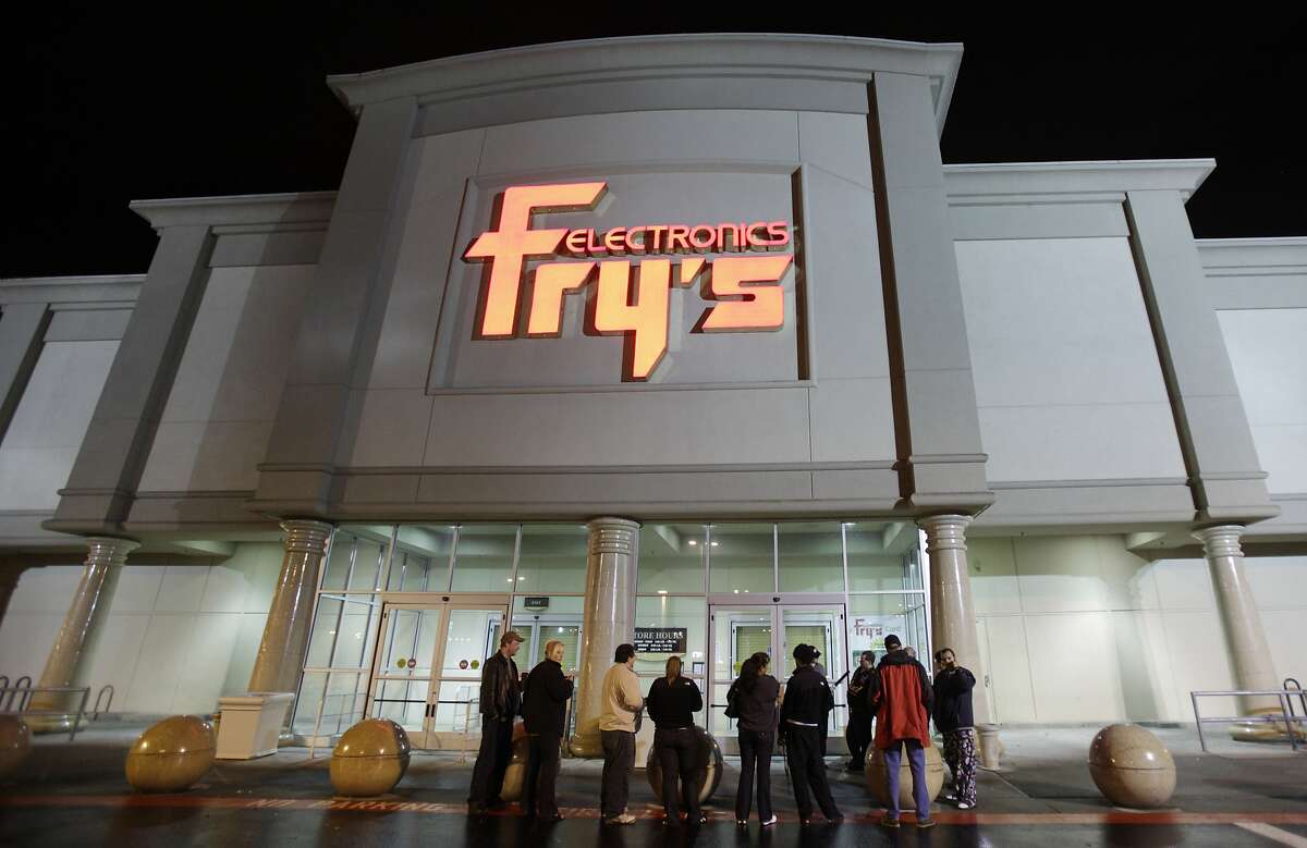 FILE- In this Oct. 21, 2009 file photo, a small crowd begins to gather outside a Fry's Electronics store in Renton, Wash. The electronics chain is permanently closing, citing the struggles it faced as a retailer during the coronavirus pandemic. The company, which was in business for 36 years, had 31 stores in nine states. Fry’s Electronics Inc. said it stopped regular operations and began the wind-down process of its business on Wednesday, Feb. 24, 2021. (AP Photo/Ted S. Warren, File)
