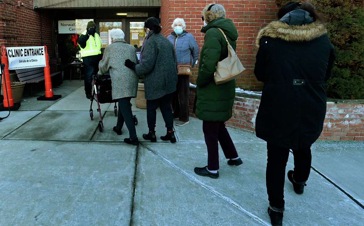 Local residents line up for their COVID vaccine Saturday, January 30, 2021, at the Norwalk Senior Center in Norwalk, Conn.