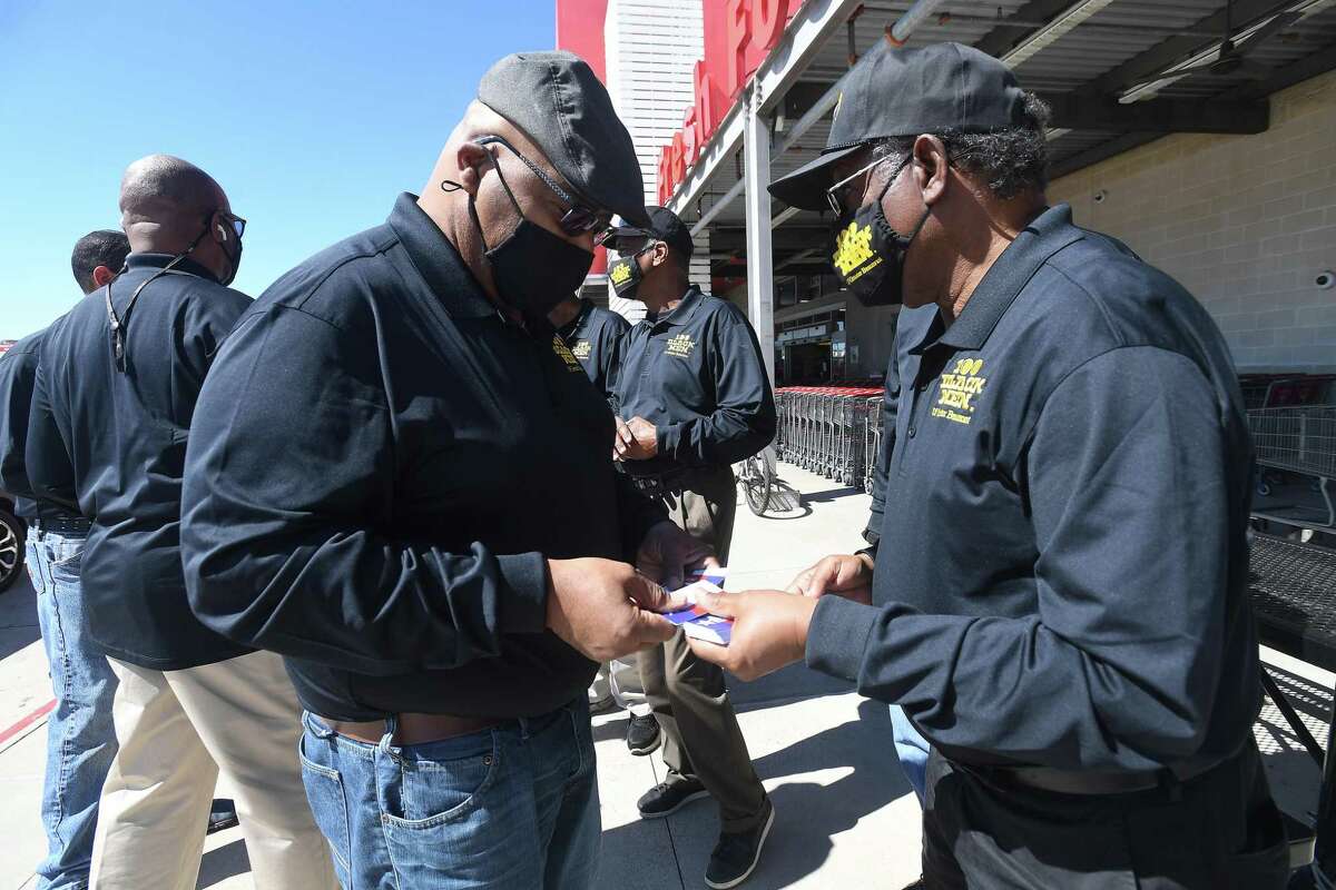 100 Black Men of Greater Beaumont's Alvin Eldridge hands off gift cards to co-member Daniel Williams as they get ready to head inside the H-E-B onn College to hand out the cards. The organization called an emergency meeting Friday in the wake of last week’s storm that impacted many in the community. They purchased 40 - $50 H-E-B gift cards and surprised customers at the check-out with the cards to help pay for their groceries. Photo made Monday, February 22, 2021 Kim Brent/The Enterprise