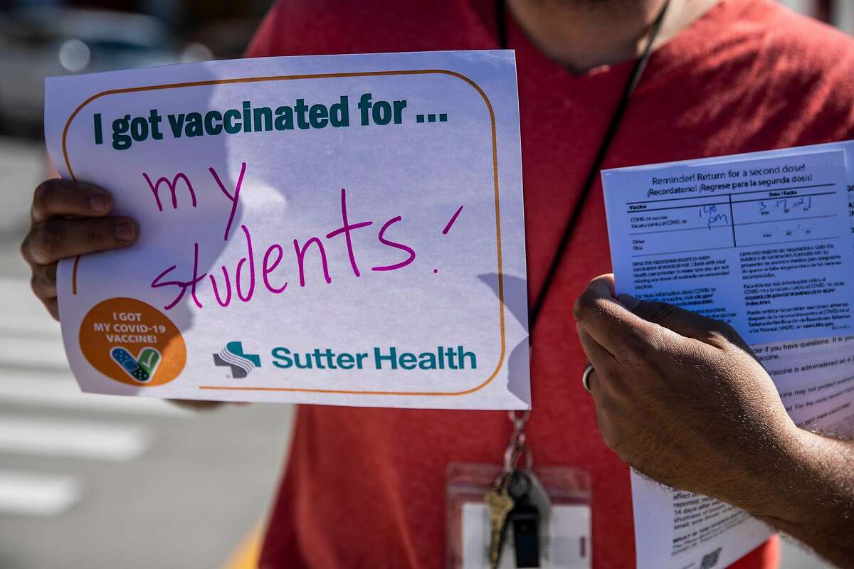 Frank Lara, a fifth grade teacher at Buena Vista Horace Mann K-8 Community School, holds a posted after receiving a COVID-19 vaccine at a clinic jointly operated by Sutter Health and the City at the San Francisco Wholesale Market in the Bayview district in San Francisco, California Wednesday, Feb. 24, 2021.