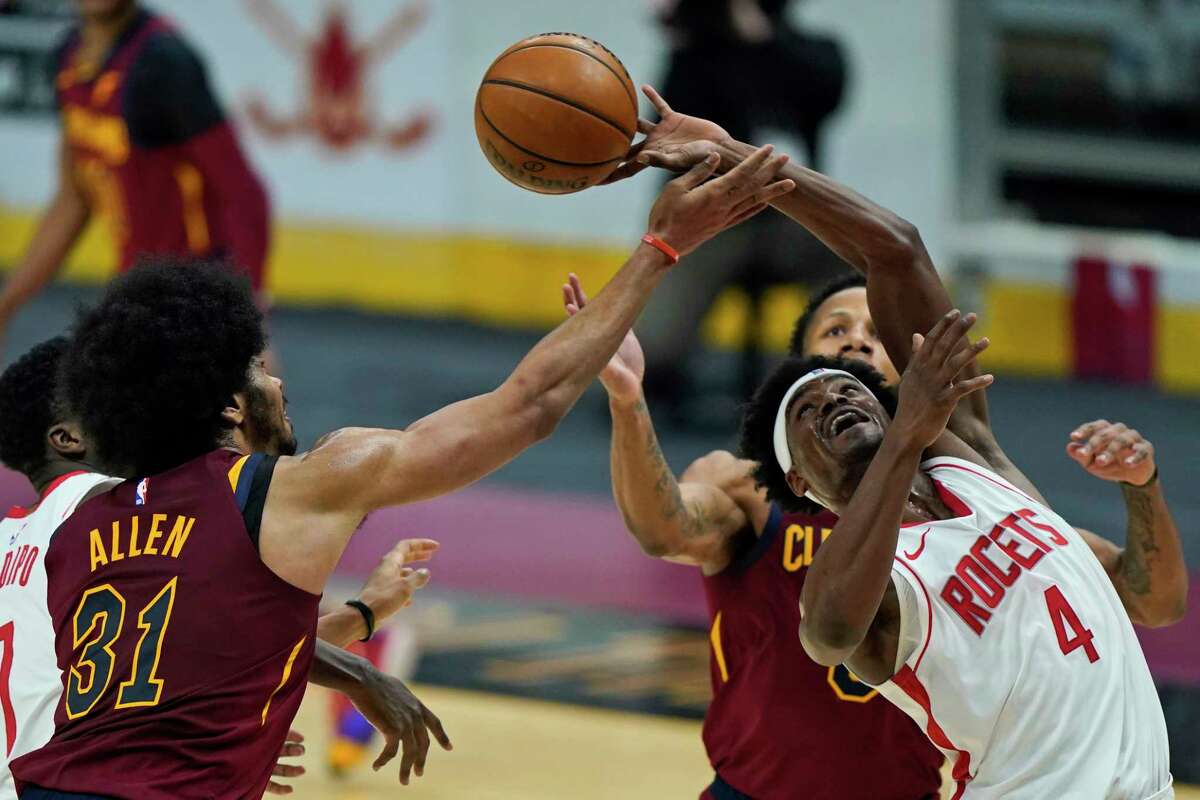 Houston Rockets' Danuel House Jr. (4) and Cleveland Cavaliers' Jarrett Allen (31) battle for a rebound in the first half of an NBA basketball game, Wednesday, Feb. 24, 2021, in Cleveland. (AP Photo/Tony Dejak)
