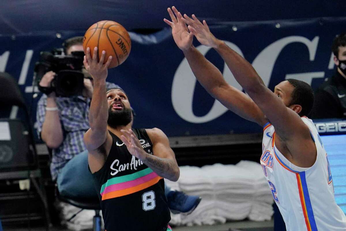 Spurs guard Patty Mills (8) shoots in front of Oklahoma City Thunder center Al Horford during the second half Wednesday, Feb. 24, 2021, in Oklahoma City.