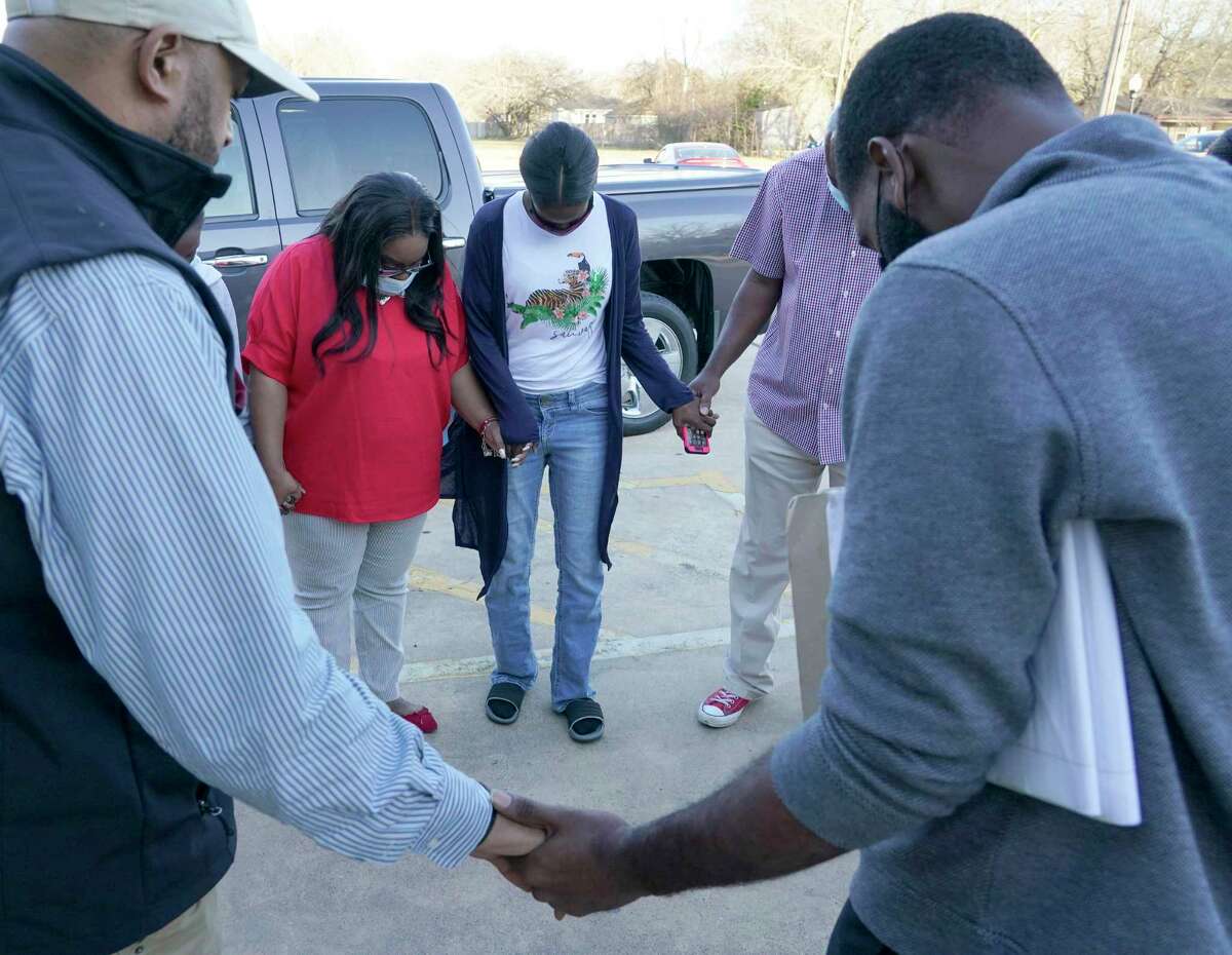 Sherkeitha Kennedy, center, is surrounded by family and friends in a prayer circle before a press conference at St. Paul Baptist Church, 1335 Waller St., Tuesday, Feb. 23, 2021 in Brookshire. DeCarerick Kennedy, 16, and his brother Faybian Hoisington, 14, the sons of Sherkeitha Kennedy were killed Feb. 21, 2021 during a Harris County car meet.