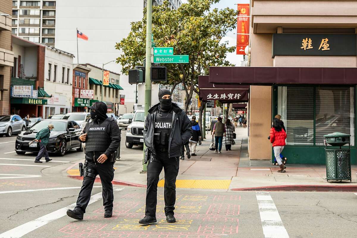 Armed security members from Goliath Protection Group, contracted and funded by a GoFundMe crowdfunding campaign, patrol on Webster Street in the Chinatown district of Oakland.