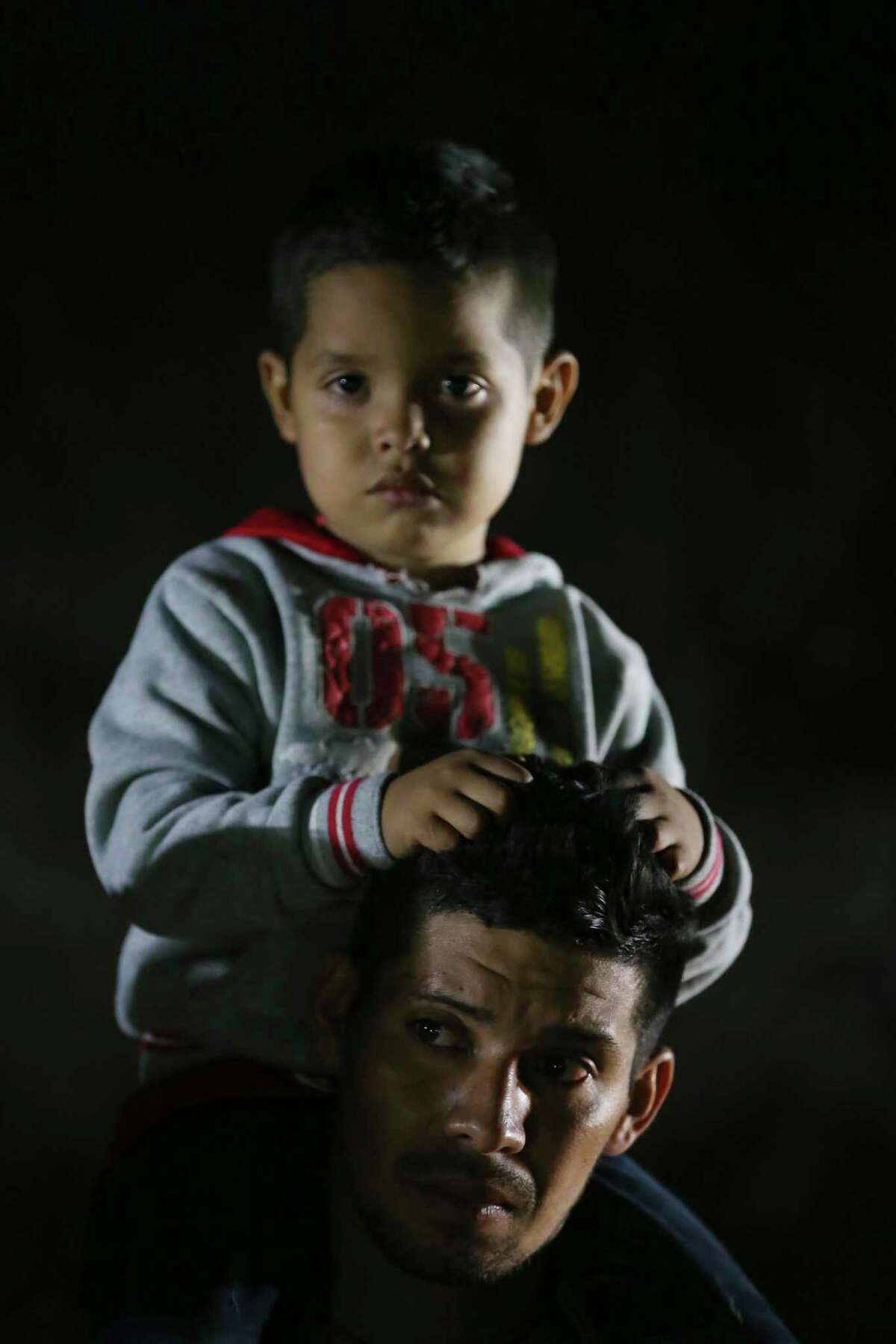 A migrant carries a child after crossing the Rio Grande into the U.S. at a placed called Rincon del Diablo, Devil’s Corner, in Hidalgo County, Texas, Wednesday, Feb. 24, 2021. Over two hundred crossed a in short time at the spot where families turn themselves into immigration authorities.