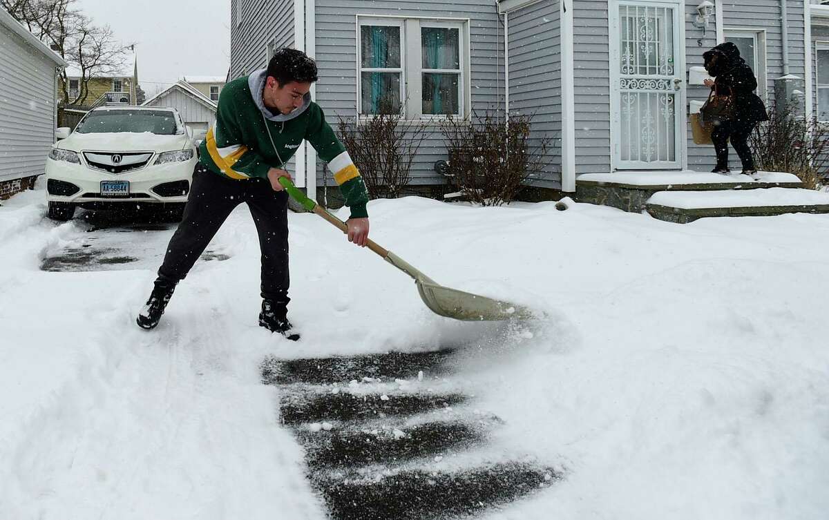 Norwalk resident Jason Torres shovels snow outside his residence on Thames Street following the first wave of snow Thursday, February 18, 2021, in Norwalk, Conn.