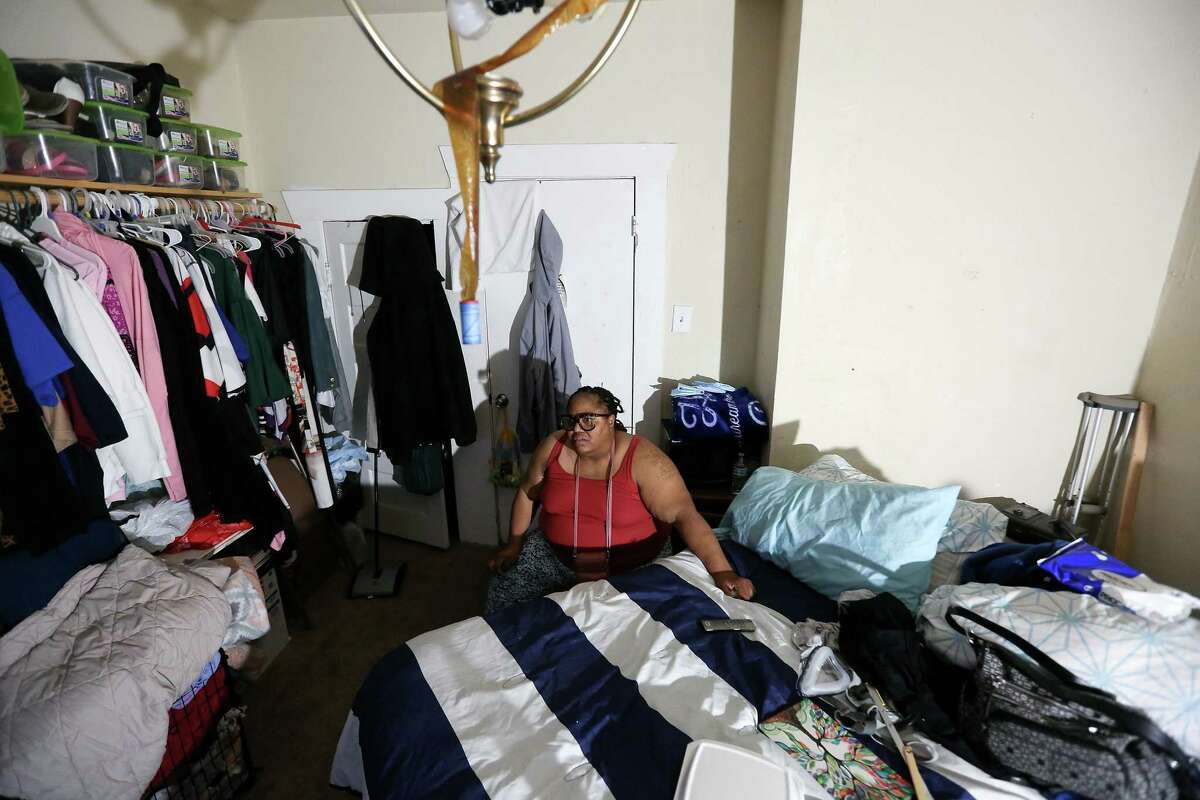 Lit by a bed-side light, Shonza Branch, 56, sits in her bedroom in her Houston on Thursday, Feb. 25, 2021. Branch spends most of her time inside bedroom since her home was heavily damaged during Hurricane Harvey and lost water in last week's storm.