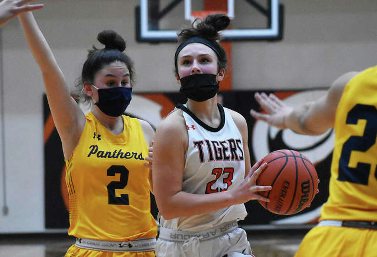 Edwardsville’s Macy Silvey (23) pulls up for a jumper at the foul line between two O’Fallon defenders during Thursday’s SWC girls basketball game at Lucco-Jackson Gym in Edwardsville.