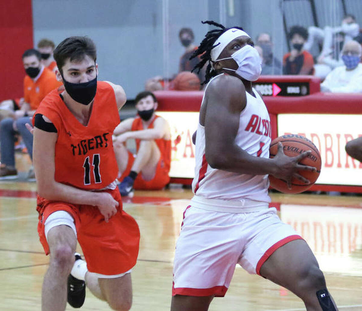 Alton’s Ja’Markus Gary (right) scored 19 points Thursday night, but the Redbirds fell to East St. Louis 59-31. He is shown in action earlier this season against Edwardsville.