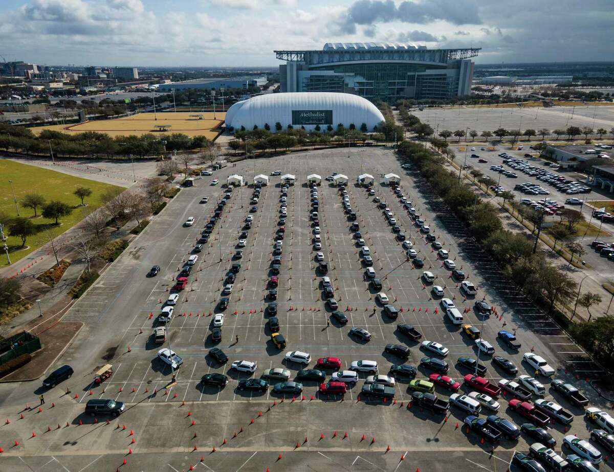 Cars line up in a parking lot at NRG Park as people wait to receive a vaccine to protect them from COVID-19 at a federally supported supersite at the Harris County facility, Wednesday, Feb. 24, 2021, in Houston.