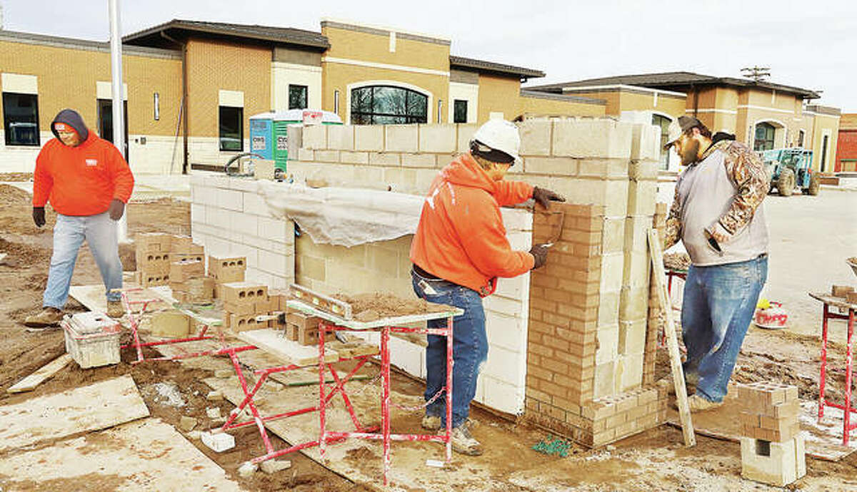 There were signs of progress Friday in front of the new $11 million Roxana Village Hall. With the exterior all but complete, bricklayers were constructing the base for a digital sign in front of the building. A stone address marker goes on the front edge of the base, right.
