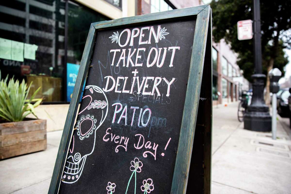 A sign outside Calavera on Tuesday, Jan. 26, 2021, in Oakland, Calif. The restaurant is open for takeout and outdoor dining at their patio.