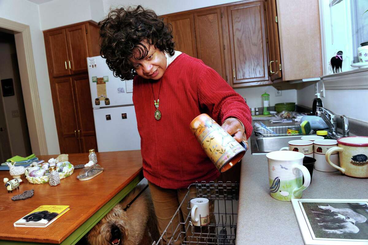 Carolyn Dion empties the dishwasher in her kitchen at Indian Fields, an affordable housing complex in New Milford on Thursday, January 12, 2012.