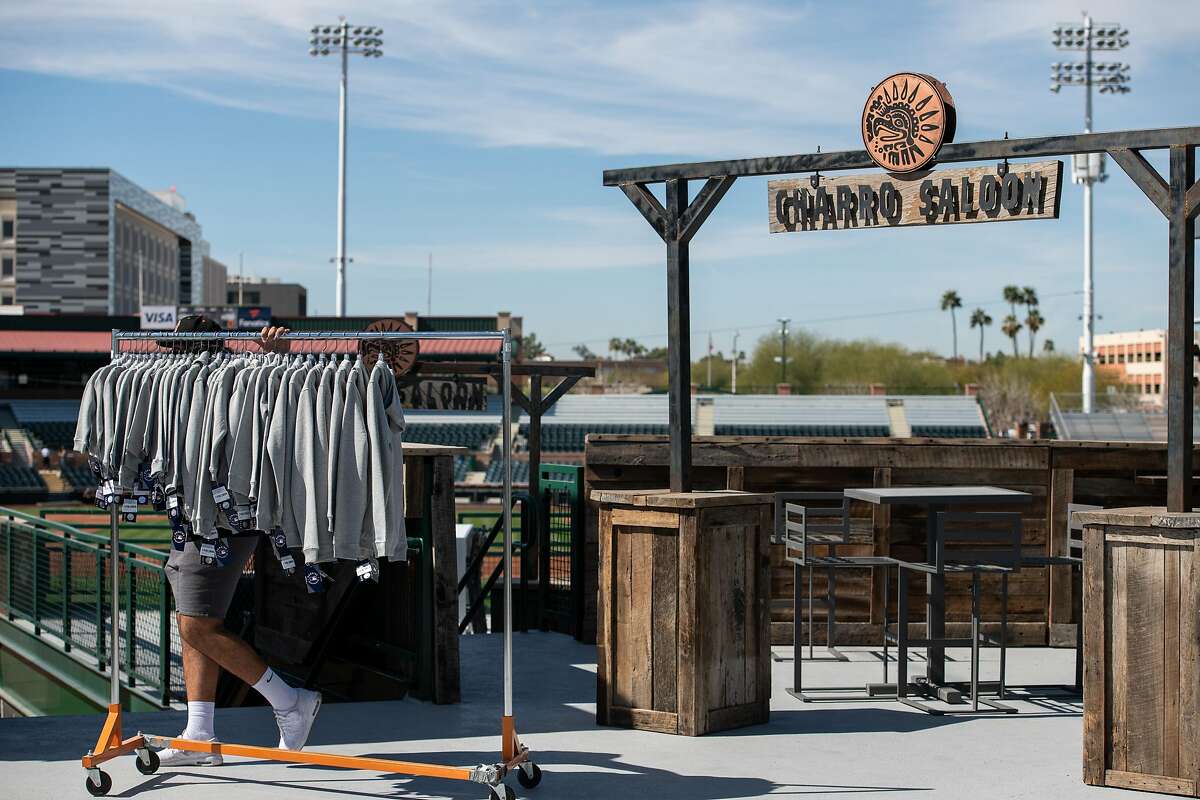 A worker pushes merchandise toward an elevator before opening day of spring training in the Cactus League at Scottsdale Stadium.