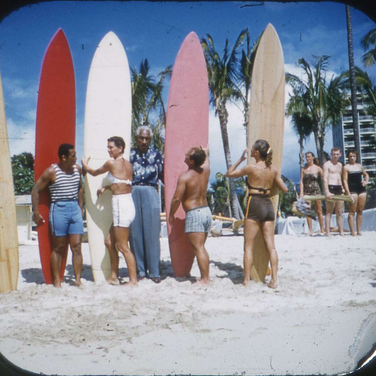 Duke Kahanamoku, center, posing with the first Hawaiian surfing team that competed in an international surfing competition in Lima, Peru. At the competition, Betty Winstedt, standing next to Kahanamoku, took first place in the women's division.