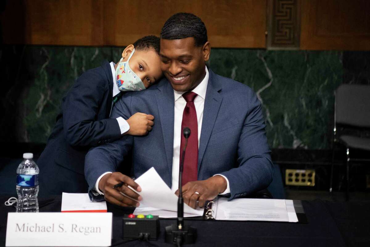 Administrator of the Environmental Protection Agency nominee Michael Regan is hugged by his son, Matthew, after his confirmation hearing before the Senate Environment and Public Works committee on Capitol Hill in Washington, Wednesday, Feb. 3, 2021. (Caroline Brehman/Pool via AP)