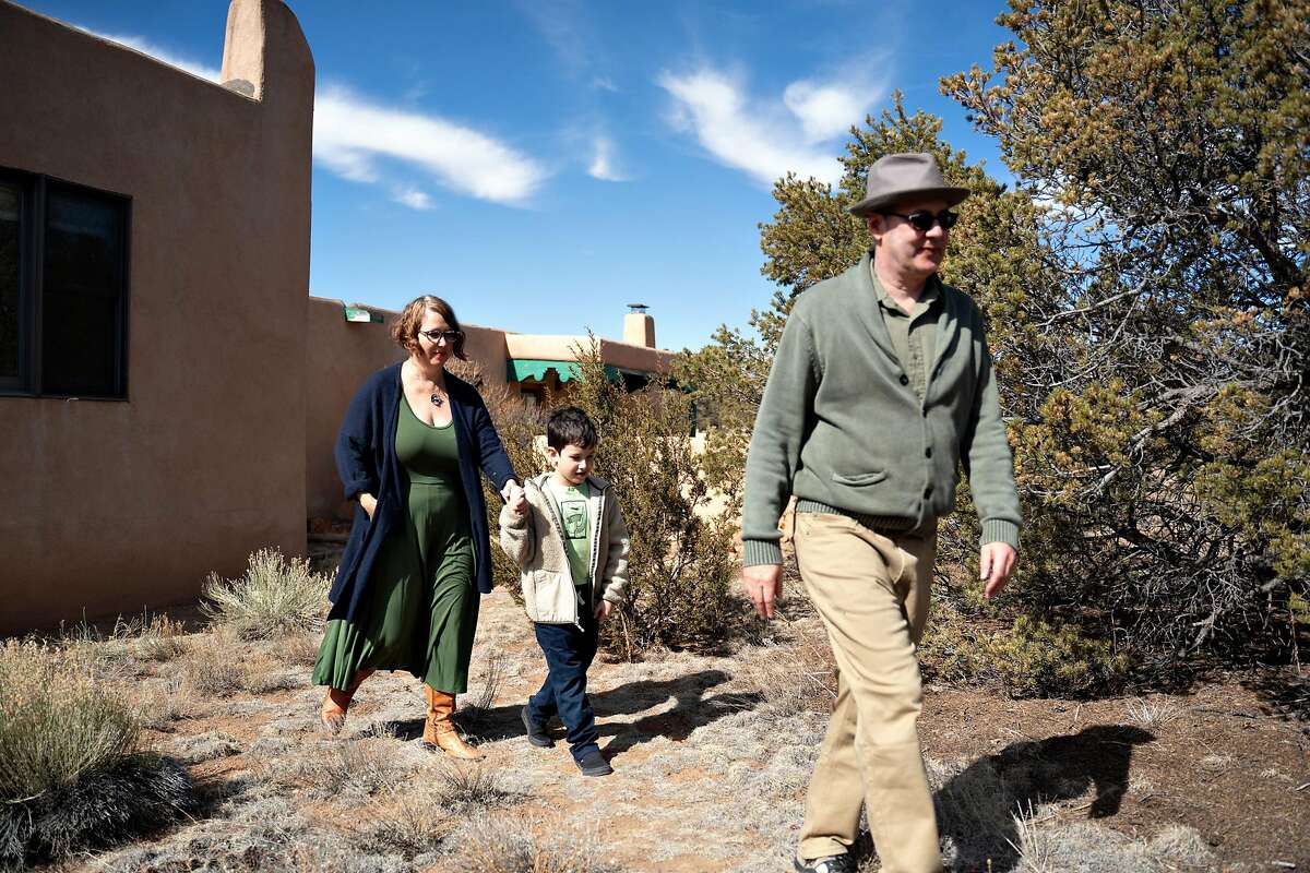 Les anciens résidents de Californie Mark Glaser et Renee Dean emmènent leur fils Everett faire une promenade sur le sentier derrière leur maison à Santa Fe au Nouveau-Mexique le 26 février 2021. Glaser et Dean ont déménagé de l'Excelsior à Santa Fe où les coûts de logement sont moins chers et il peut travailler à distance.